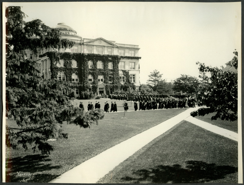 Probably either a commencement procession or recession held in 1930. Beardshear Hall is in the background.