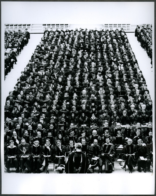 Students and faculty are seated listening to a speaker at commencement ceremonies in Hilton Coliseum, 1972.