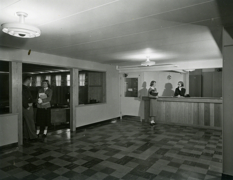 Lobby at Westgate Hall in 1955. On the left, John Holdefer, and Rosemary Atwood are seen; at right, are Mary Thomson and Margaret Erickson.