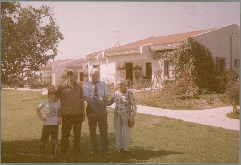 Earl O. Heady in front of kibbutz members' houses in Israel, with Oren, Samuel, and Miriam Dvoskin, 1983