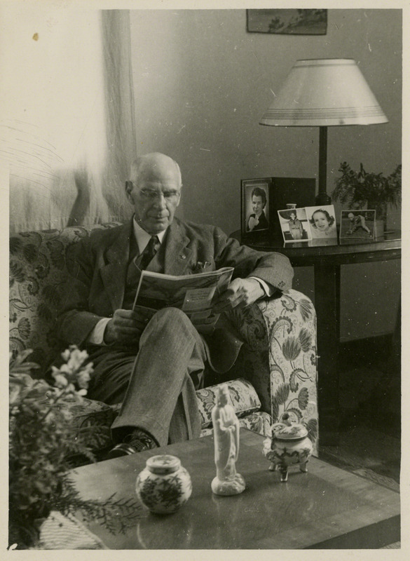 J. Brownlee Davidson, founder of Agricultural Engineering Department at Iowa State College, sitting in chair and reading.