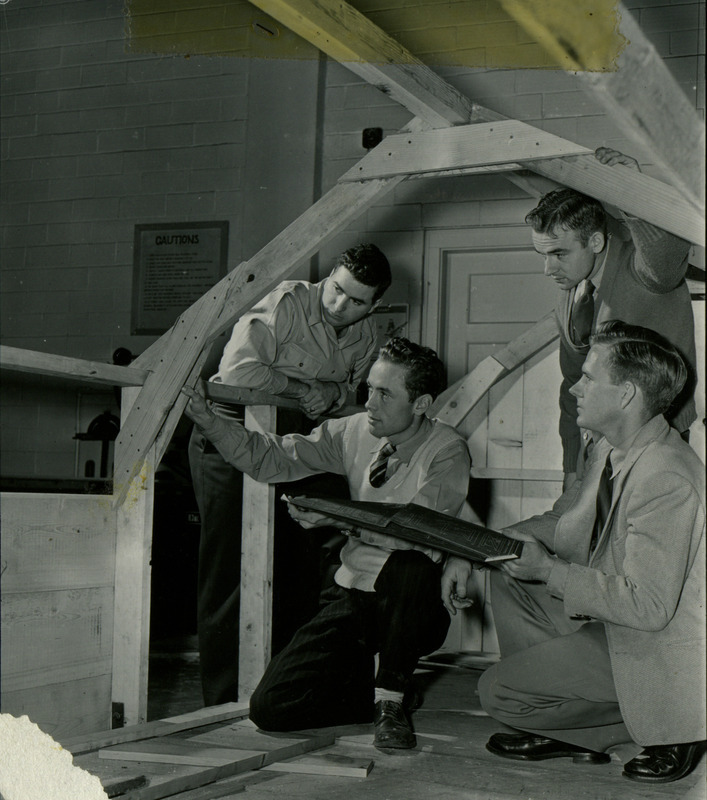 J. Bruce Liljedalh and three students examine a the strength of a wooden truss on a building model.