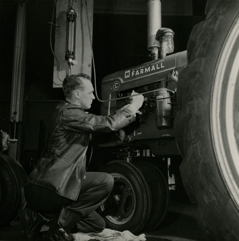 Dilver Alchrist Paugtian is working on the motor of a McCormick-Deering Farmall tractor.