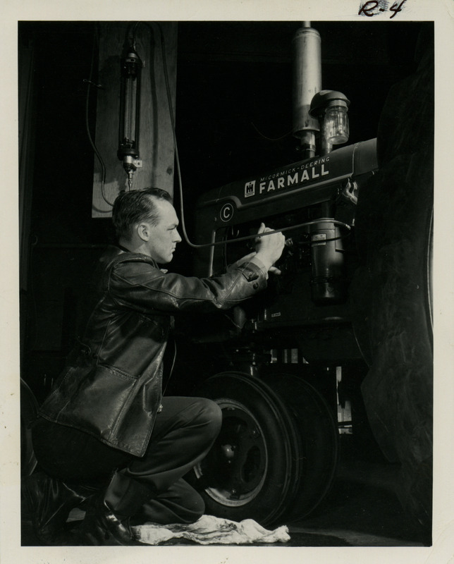 Dilver Alchrist Paugtian is working on the motor of a McCormick-Deering Farmall tractor.