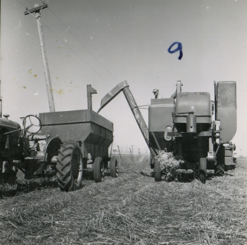 A farmer watches his combine unload crops into the adjacent wagon pulled by a tractor, in Washington County, Iowa.