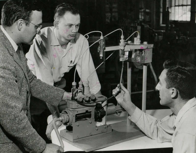 Don Hunt (left), graduate student Graeme Quick from Australia (center) and Clarence Bockhop (right) work with scientific apparatus in the Farm Machinery Lab.