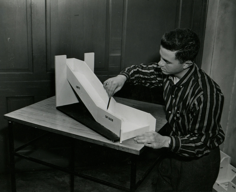 Bob Davis studies the stilling basin of a chute model which is used in soil erosion control.