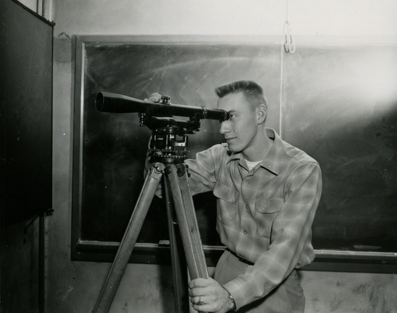 Agricultural engineer John Teeter uses an engineer's level in soil and water conservation work.