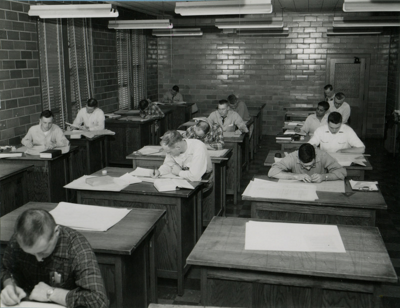 Students work at large desks in the Drafting Lab.