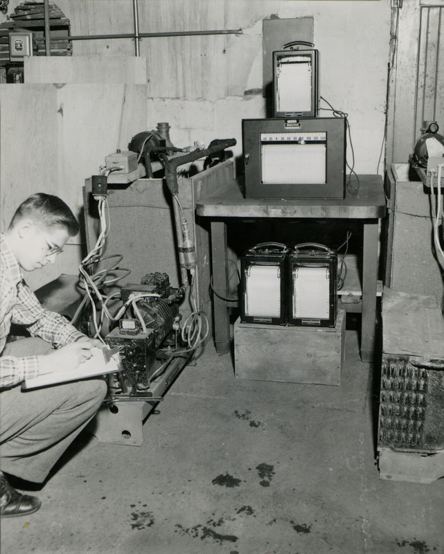 John Hermnson, agricultural engineering senior, takes notes on a refrigeration experiment. Instruments record temperatures and electrical information, which will be used in the engineering report.