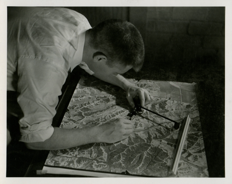 A student uses tools on a relief map.