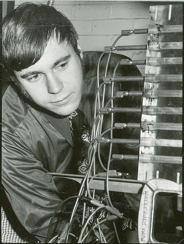 A researcher examined a piece of equipment that consists mainly of plugs with attached wires. Several of the plugs are inserted into metal tubes that are mounted on a frame.