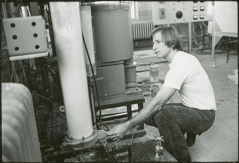 A researcher checks the connections for a piece of tubing that runs between two pieces of equipment.