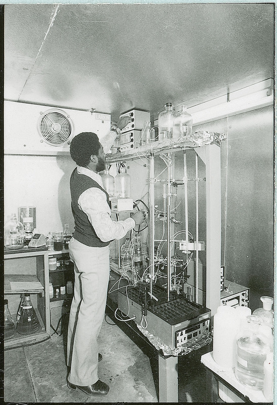 A researcher is adjusting a dial control on a piece of laboratory equipment.