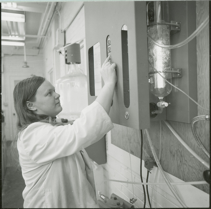 A researcher adjusts a large wall mounted piece of equipment. This photograph was featured in the Chemical Engineering Brochure for 1978.