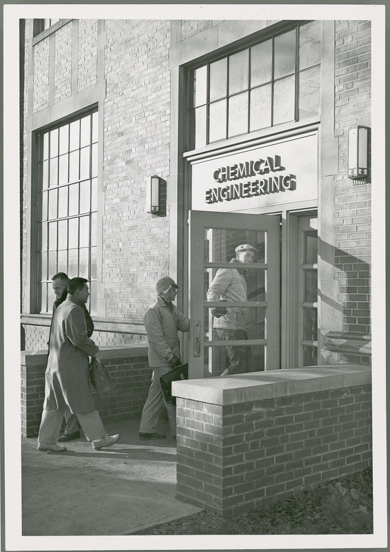 Men are entering and exiting the Chemical Engineering Building which was renamed Sweeney Hall in 1964.