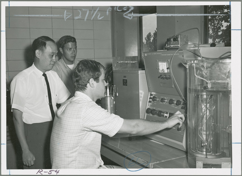 A graduate student is operating the Potentiometer Facility in the testing of the thermal conductivity of starch as Dr. Tsao and another student look on.