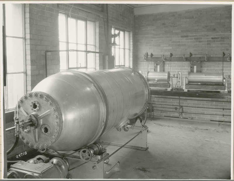 A large Reeves tank rotated by pulleys is on the left. Two other cylindrical drums are in the background.