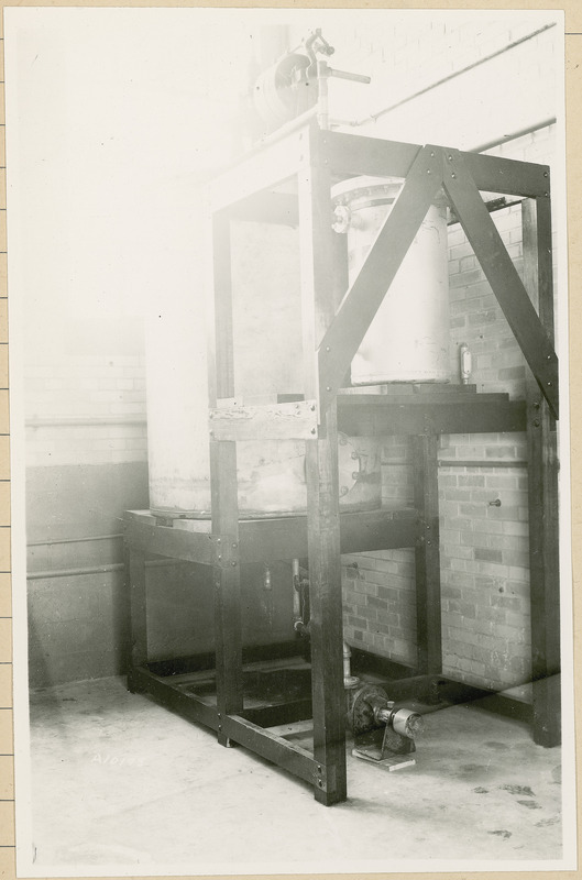 Two large containers are sitting on a shelving unit.