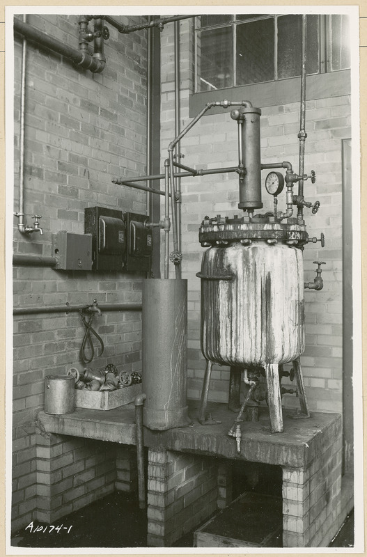 This piece of equipment is bolted to a concrete table. On the left is a box of assorted valves and other parts and a paint can.