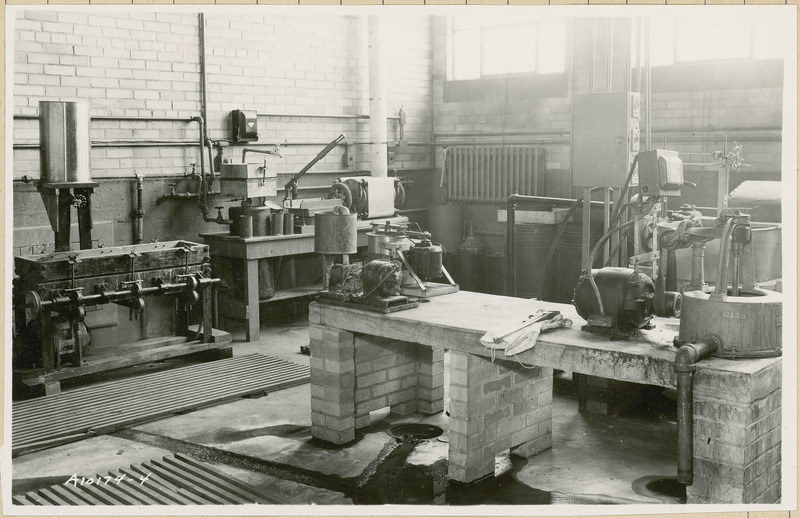 This lab contains various pieces of equipment. A brick table is in the foreground. A substance is flowing on the floor.