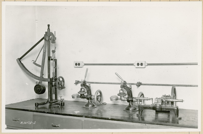 This collection of scales includes a pendulum scale on the left and two Mullen testers in the center.