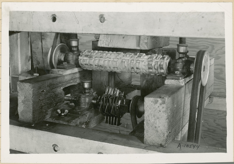 This close up of the front of the corn machine shows the rotating parts operated by pulleys.