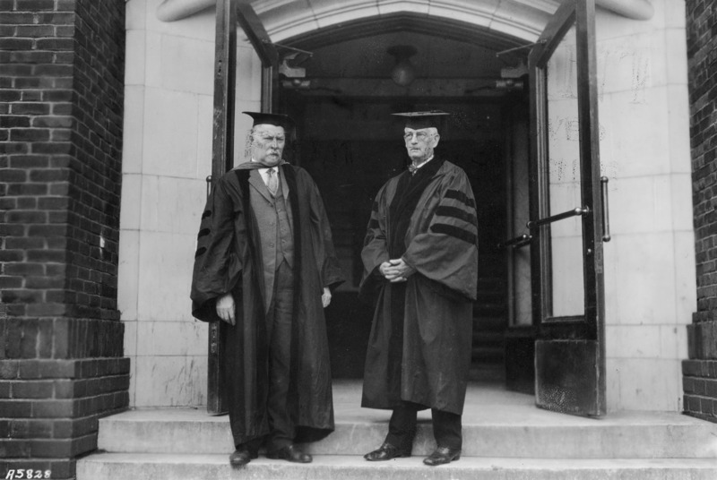 Parley Sheldon, Mayor of Ames, is standing to the right of Dr. Pammel in an open doorway. Both men are dressed in academic robes.