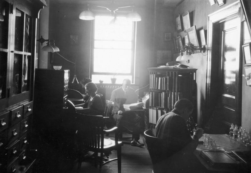 This private office of the Botany Dept. Head is being shared with an instructor, fellowship student, and graduate student. The photo illustrates the overcrowded work conditions and was used to request legislative appropriations. Dr. Pammel is seated at the back of the room.