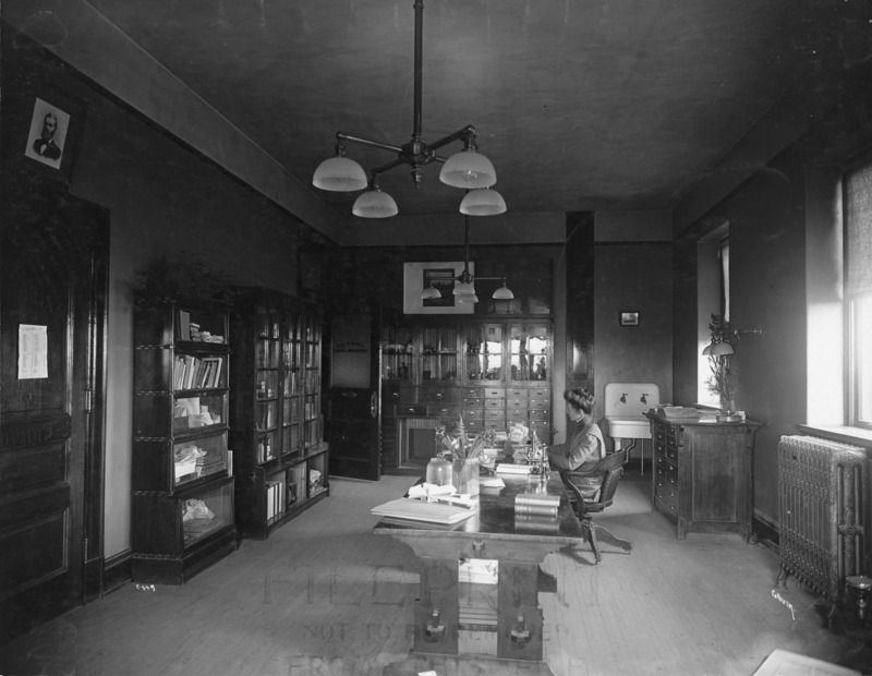 Charlotte King is working at a desk in the Botany Lab in Central Building (Beardshear Hall).