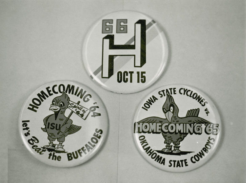 Three homecoming buttons dated 1966, 1965 and 1964 are shown together in a display.