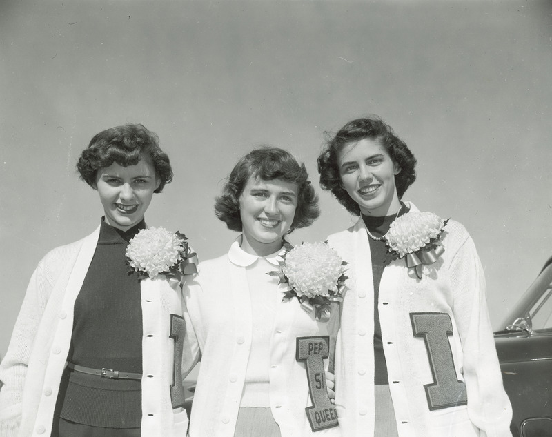 The homecoming queen candidates for 1951 are shown wearing a white cardigan letter sweater and mum corsage. They are from left to right: Bonnie Helfrich, Doris Blair (queen) and Ann Bradley.