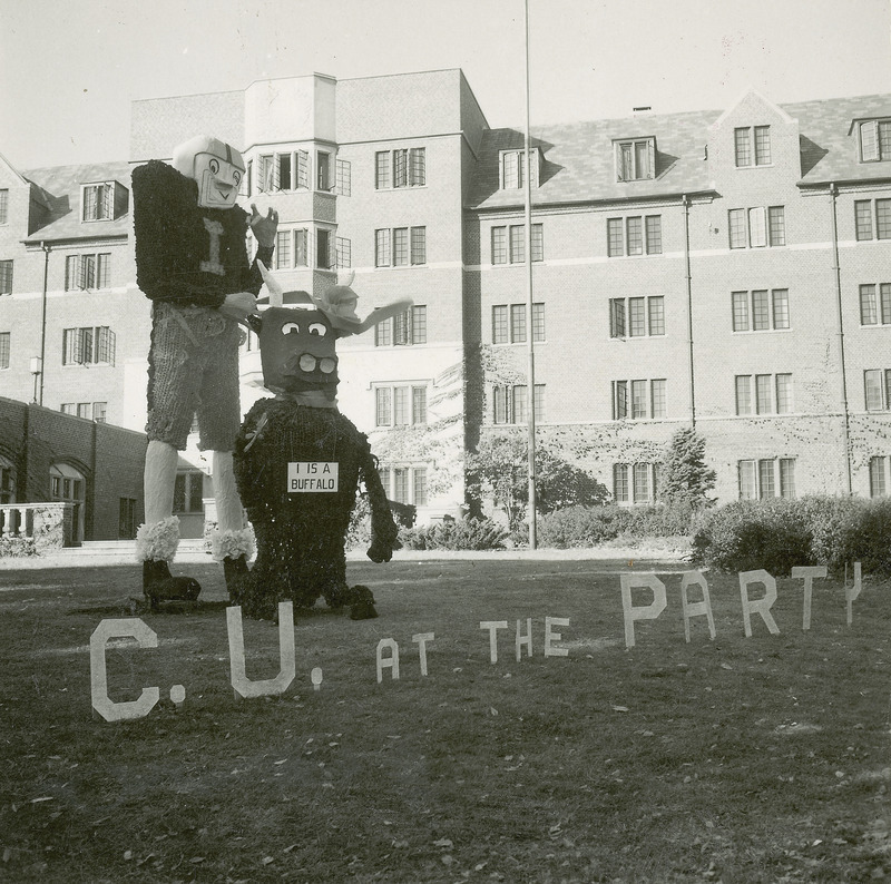 A large football player with the letter "I" on his jersey is standing behind a smaller figure of a buffalo. The buffalo has a sign around its neck saying, "I is a buffalo." Before the two figures the phrase, "C.U at the Party," is spelled out in separate letters.