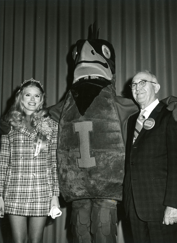 Cy, the ISU mascot is standing between the alumni queen, Gwen Federicks and H.D. "Pete" Wilson (Cy's favorite alum) They are (left to right): Gwen Federicks, Cy, H. D. "Pete" Wilson.