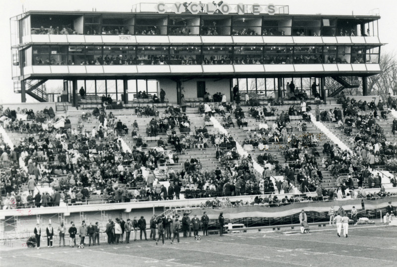 The football stadium bleachers are filling up before the 1970 Homecoming game.