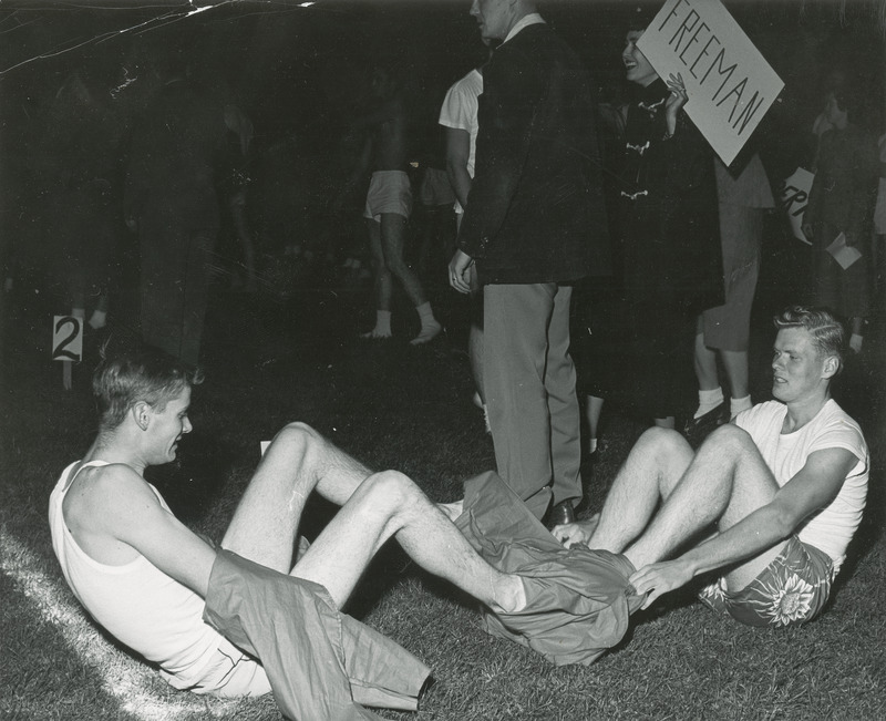 Two men are scrambling to get into pajamas in the Pajama relay at the Homecoming Pep Barbeque.