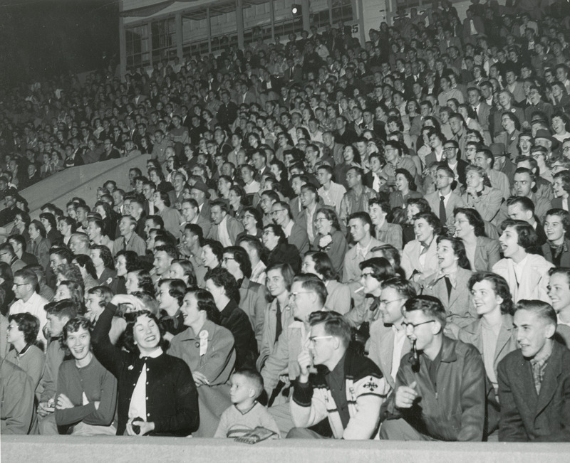 The crowd sitting in the stadium is enjoying the activities at the Pep Barbeque.