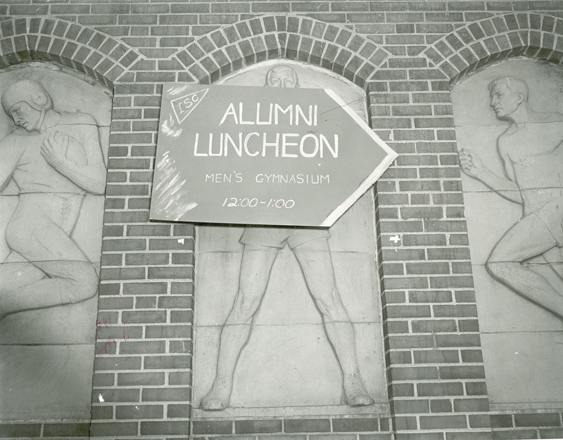 A sign outside State Gym directs Alumni to the Homecoming Alumni Luncheon.