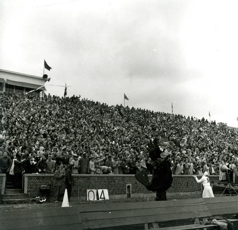 A cheerleader and Cy perform before the crowd at the Iowa State vs. Kansas State Homecoming Game at Clyde Williams Field.