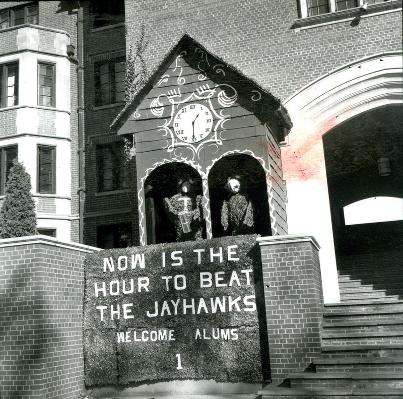 Stevenson House captured first prize in the Men's Resident Association lawn display, "Now is the Hour to Beat the Jayhawks--Welcome Alums." The display features a cuckoo clock with Cy ready to pound the head of a Jayhawk.