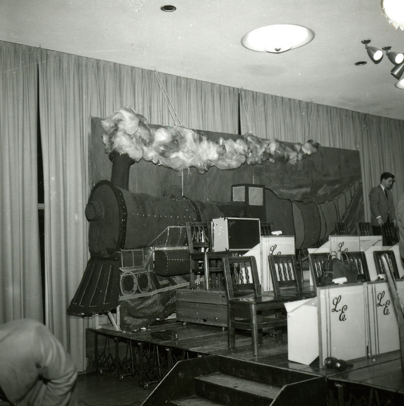 The stage is set up for the Les Elgart band with a backdrop of a train for the Homecoming Dance, 1965.