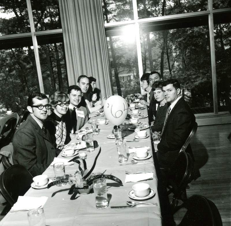 Members of the Class of 1964 sit together at a table at the Homecoming Banquet, 1969.