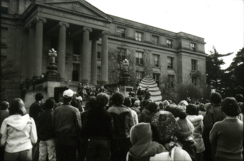 Students attend a Homecoming Pep Rally in Central Campus on the steps of Curtiss Hall, featuring a skit with a beehive, 1977.