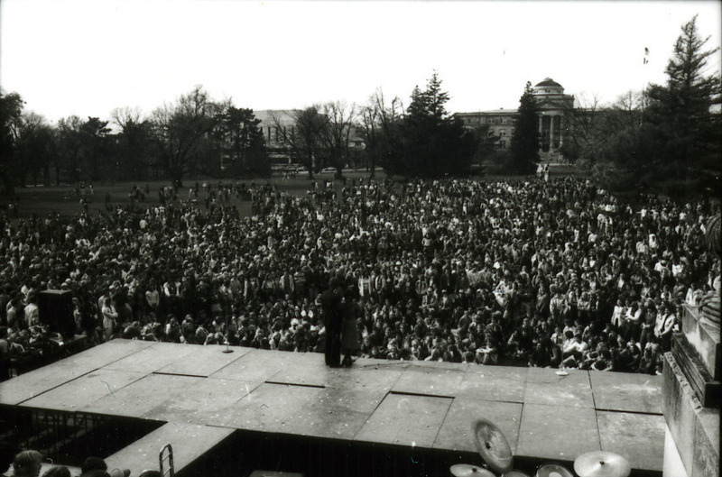 The Homecoming Pep Rally is shown from the view from the stage, looking across the crowd in Central Campus towards Beardshear Hall, 1977.