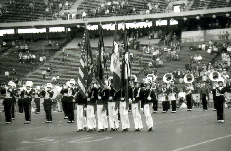 The military color guard performs with the ISU Marching Band on the football field at Homecoming, 1985.