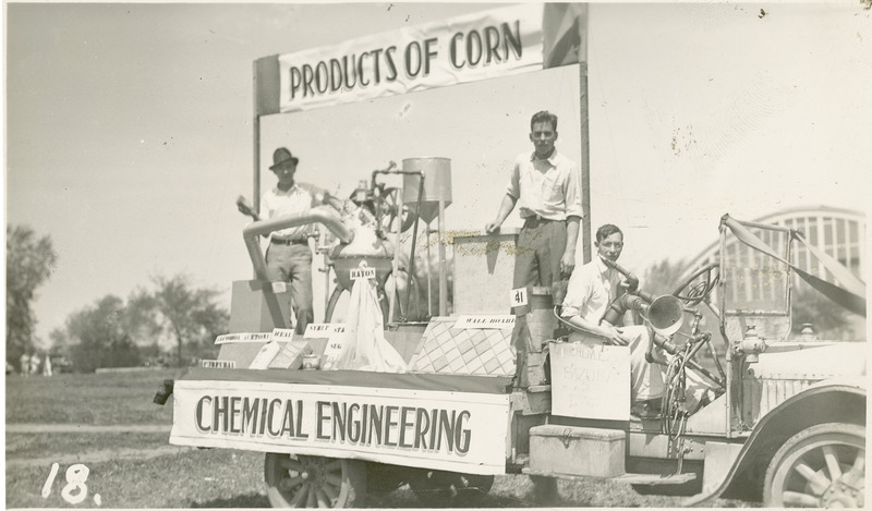 A 1937 VEISHEA parade float from the Department of Chemical Engineering. "Products of Corn." Three men on the float showing various equipment that help produce corn products such as meal, syrup, rayon, and wall board.