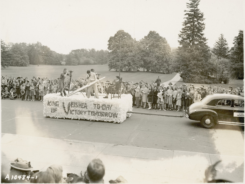 A 1942 VEISHEA parade float from the Department of Civil Engineering. "King of VEISHEA Today Victory Tomorrow." Four men are on this float with surveying equipment and other items.