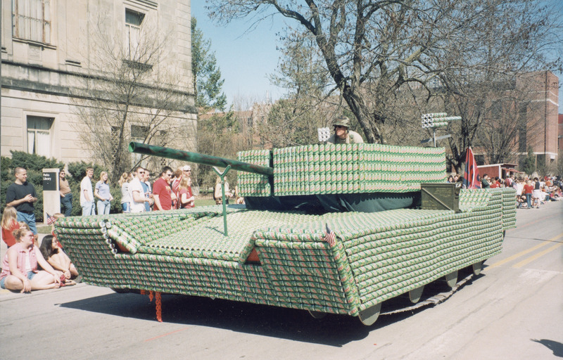 A VEISHEA parade float most likely from R.O.T.C. or Military Science. A student in fatigues drives a tank made of Mountain Dew cans.