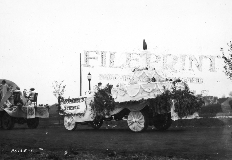 A VEISHEA Household Science float. The float, built on a flat bed truck, exhibits a giant birthday cake with one candle in celebration of the "first birthday" of VEISHEA. See photograph no. 1722-4-8 for a different view of this same float.