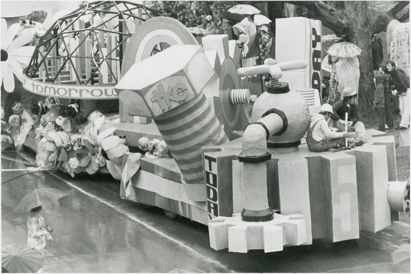 The 1973 Tau Kappa Epsilon float. Member of the fraternity are sitting on cogs and bolts, are dressed as builders with hard hats and are building for tomorrow, today.